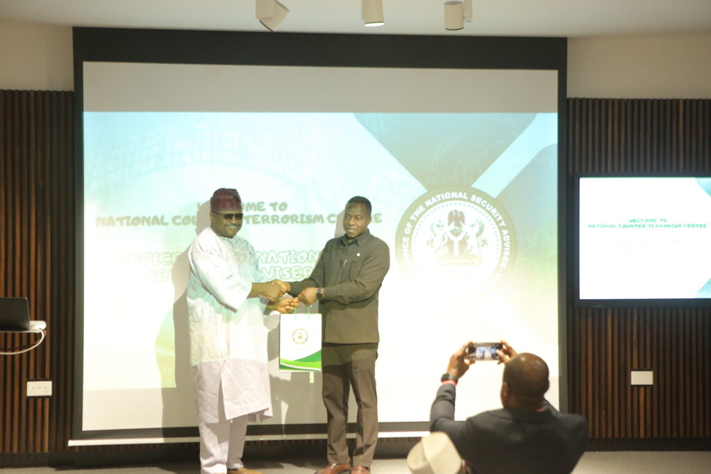 The National Coordinator (right) presenting a Souvenir to the leader of NSUK delegation and Director of the Institute of Governance and Strategic Studies, Prof. Andrew Zamani. 
