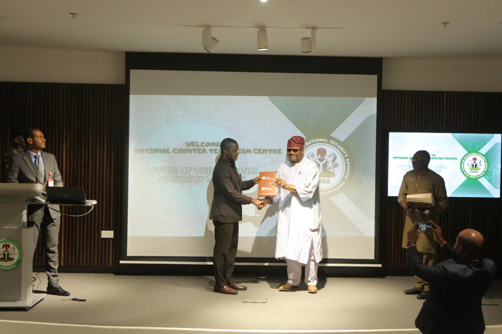 Retired Rear Admiral YEM Musa (left) receiving a present from Prof. Andrew Zamani (right).